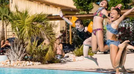 Enfants au bord de la piscine du camping Les Sables du Midi